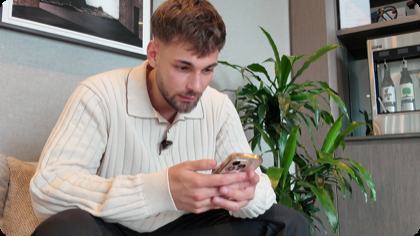 QT Funded trader interview still — funded trader reviewing his phone