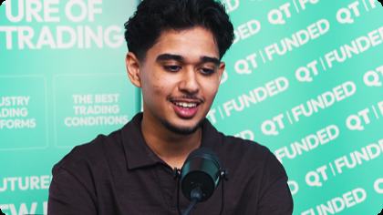 QT Funded trader interview still — funded trader speaking on camera in front of a QT Funded branded backdrop